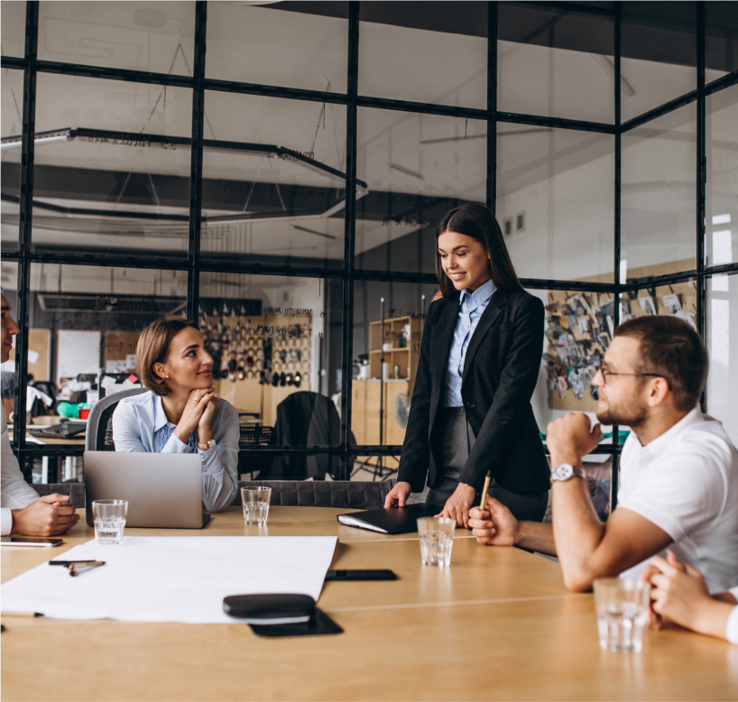 Un groupe de 
                    personnes qui discute autour d'une table en entreprise